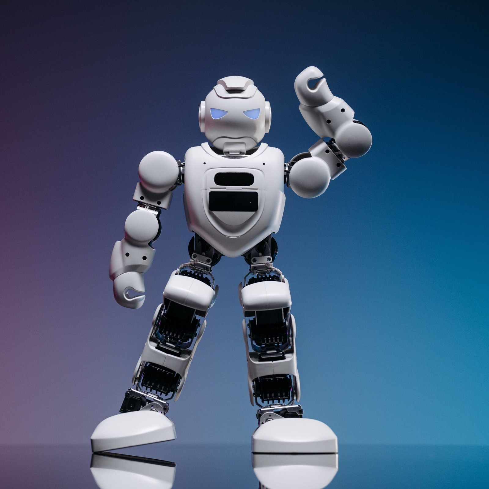 A sleek white robot in a studio setting against a gradient background, showcasing modern robotics.